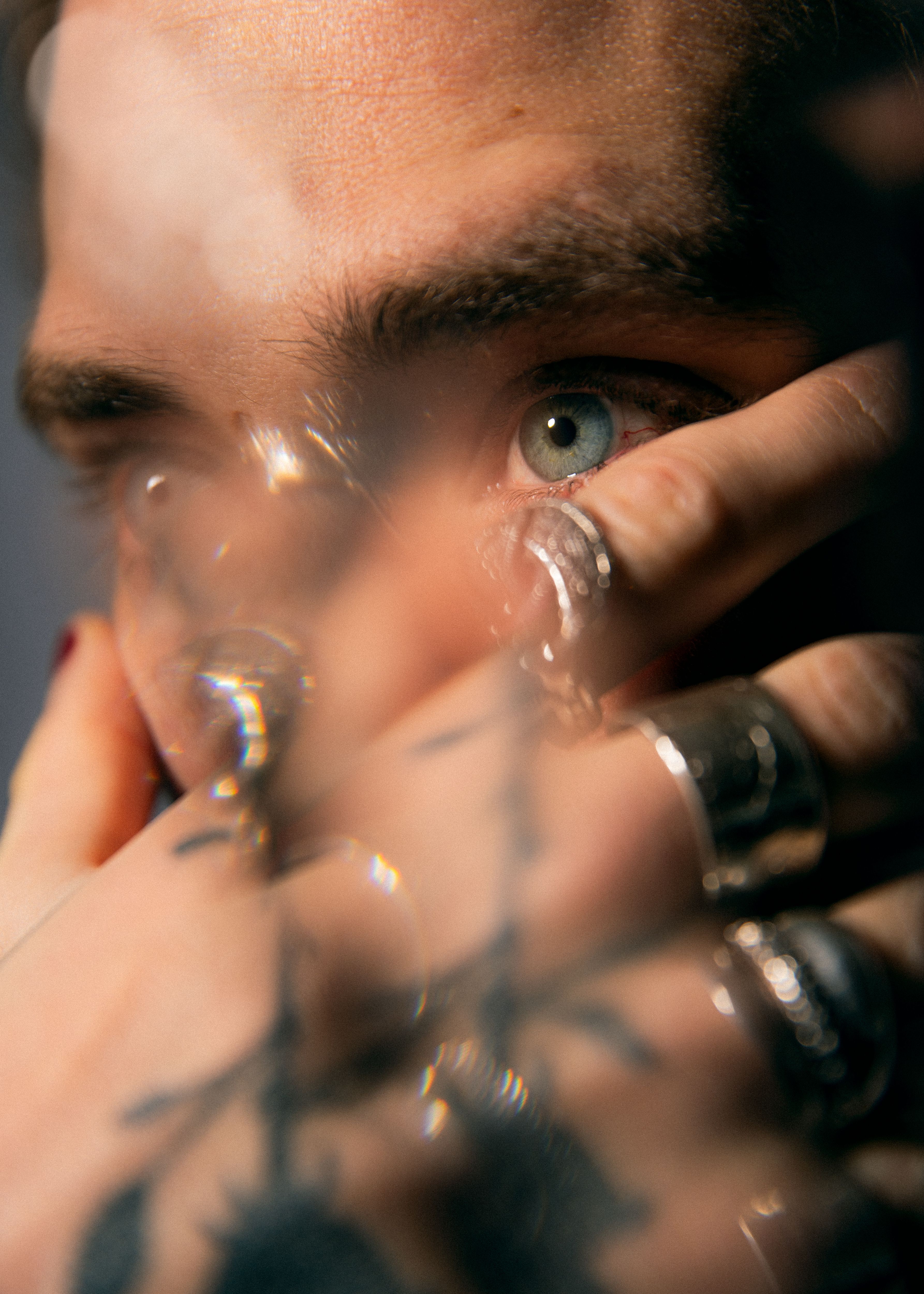 We´re close on a man´s face. His face is covered by his hand.